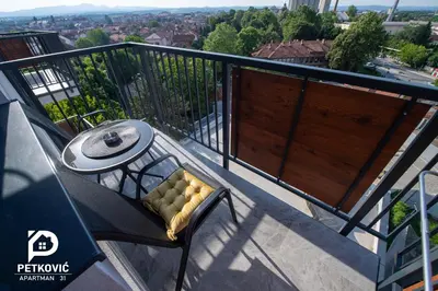 a balcony with a table and chair on a balcony at Petković apartmani 31 STUDIO in Jagodina