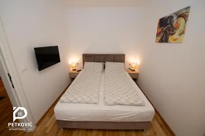 a small bedroom with a bed and two night stands at Petković apartmani 34 in Jagodina