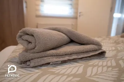 a pile of towels sitting on top of a bed at Petković apartmani 34 in Jagodina