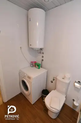 a bathroom with a toilet and a washing machine at Petković apartmani 34 in Jagodina