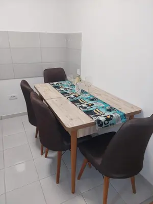 a dining room table with black chairs around it at Apartman Muzika Jagodina in Jagodina