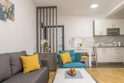 a living room with a gray couch and yellow pillows at Apartman Ina in Vrnjačka Banja