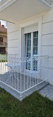 a porch with two chairs on a house at Apartman Ina in Vrnjačka Banja
