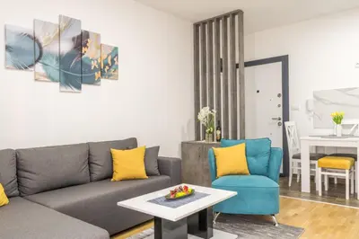 a living room with a gray couch and two blue chairs at Apartman Ina in Vrnjačka Banja
