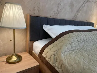 a bedroom with a bed with a lamp on a table at Bora Apartmani - FREE PARKING - CITY CENTER in Vranje