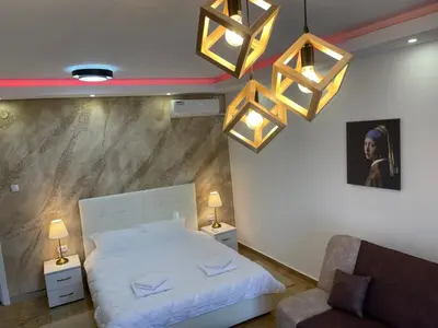 a bedroom with a bed and a chair and lights at Bora Apartmani - FREE PARKING - CITY CENTER in Vranje