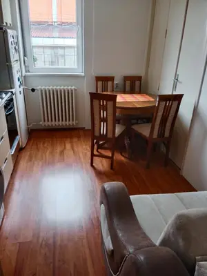 a living room with a table and chairs and a kitchen at Apartman Dragana in Pirot
