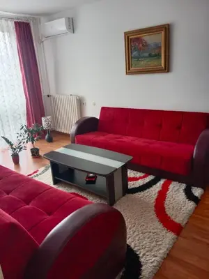 a living room with a red couch and a table at Apartman Dragana in Pirot
