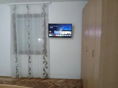 a room with a shower curtain and a tv on a wall at Green apartments 2 in Kuršumlija