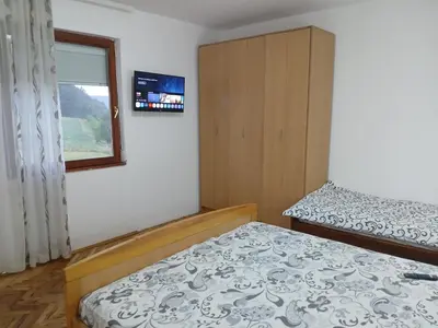 a small bedroom with a bed and a window at Green apartments 2 in Kuršumlija