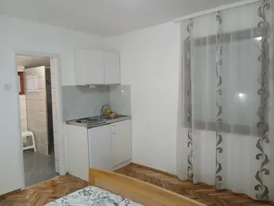a kitchen with white cabinets and a counter top at Green apartments 2 in Kuršumlija