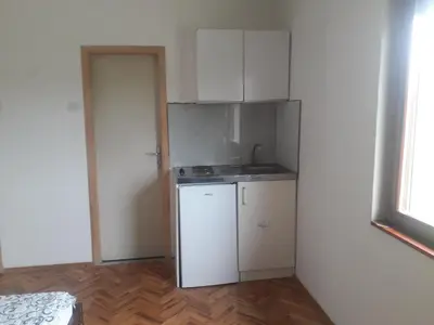 a small kitchen with white cabinets and a sink at Green apartments 2 in Kuršumlija