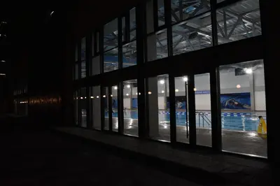 an empty building with a pool seen through the windows at Lux Apartman Crnjanski II, Jagodina in Jagodina