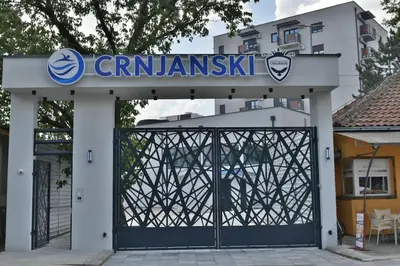 a gate to a building with a sign on it at Lux Apartman Crnjanski II, Jagodina in Jagodina