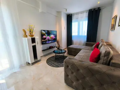 a living room with a couch and a flat screen tv at Lux Apartman Crnjanski II, Jagodina in Jagodina