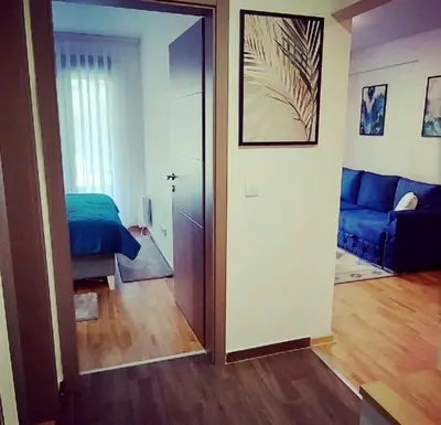 a bedroom with a blue bed and a mirror at Apartman SANA & Free GARAŽA in Vrnjačka Banja