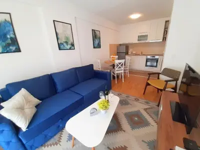 a living room with a blue couch and a table at Apartman SANA & Free GARAŽA in Vrnjačka Banja