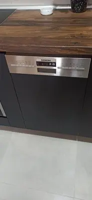 a dishwasher in a kitchen with a wooden counter top at Lux apartment 13 center, free parking in Niš