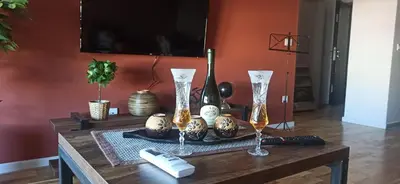 a wooden table with two wine glasses on it at Lux apartment 13 center, free parking in Niš
