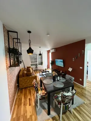 a living room with a table and a couch at Lux apartment 13 center, free parking in Niš