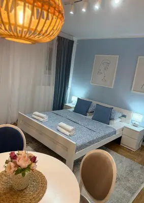a bedroom with a bed and a table and chairs at Apartman Indigo in Vrnjačka Banja