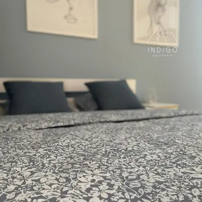 a bedroom with a bed with a black and white bedspread at Apartman Indigo in Vrnjačka Banja