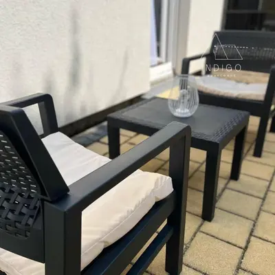 two black chairs and a table on a patio at Apartman Indigo in Vrnjačka Banja