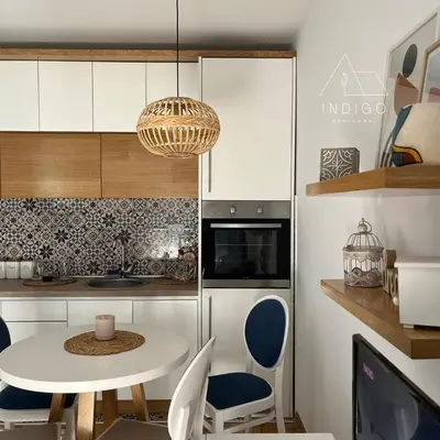 a small kitchen with a white table and chairs at Apartman Indigo in Vrnjačka Banja