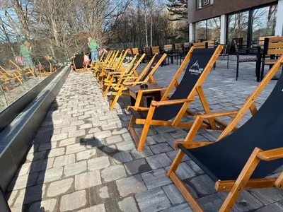 a row of lawn chairs sitting on a sidewalk at Kopaonik Heights N97 Spa and Wellnes in Kopaonik