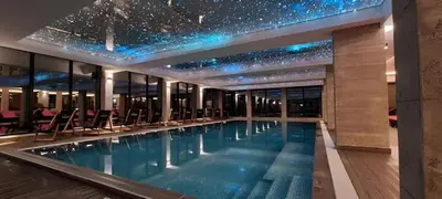 a swimming pool in a building with stars on the ceiling at Kopaonik Heights N97 Spa and Wellnes in Kopaonik