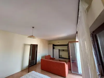 a living room with a red couch and a mirror at City Park Rooms in Vranje