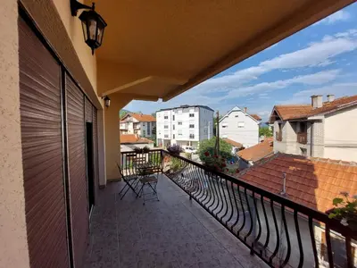 a balcony with chairs and a view of a city at City Park Rooms in Vranje