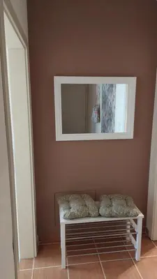 a bench sitting in a room with a mirror at Apartman Ninolić in Jagodina
