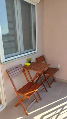 two wooden chairs and a table on a balcony at Apartman Ninolić in Jagodina
