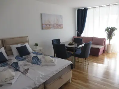 a bedroom with a bed and a table and a couch at Lux apartment 10 center, free parking in Niš