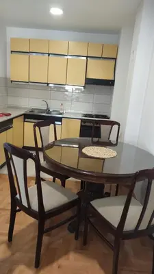 a kitchen with a table and chairs in a room at Stan na dan Nis in Niš