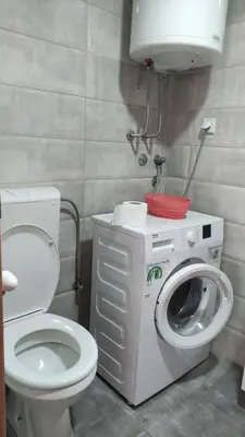 a bathroom with a toilet and a washing machine at Stan na dan Nis in Niš