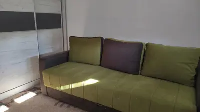 a green couch sitting in a room at Stan na dan Nis in Niš