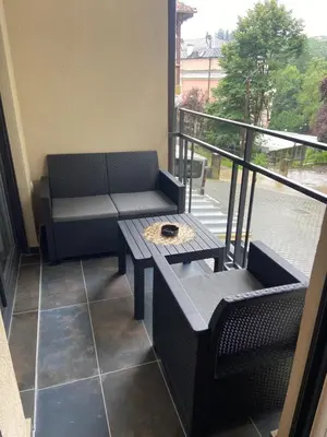 a balcony with a bench and a table on a balcony at Soul Apartment Vrnjačka Banja in Vrnjačka Banja