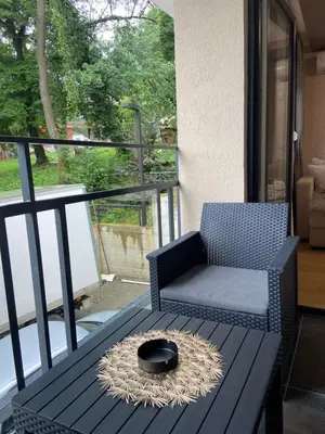 a table with a chair and a bowl on a balcony at Soul Apartment Vrnjačka Banja in Vrnjačka Banja