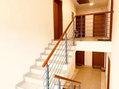 a staircase in a home with a white stair case at Apartman Vrnjačka Banja centar in Vrnjačka Banja