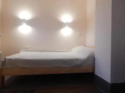 a bed with two lights on the wall at Apartman Luka in Vrnjačka Banja