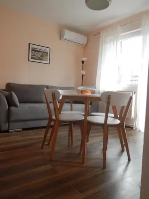 a dining room table and chairs in a living room at Apartman Luka in Vrnjačka Banja