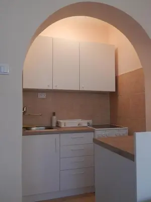 an arched kitchen with white cabinets and a sink at Apartman Luka in Vrnjačka Banja
