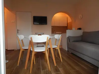 a table and chairs in a living room with a couch at Apartman Luka in Vrnjačka Banja
