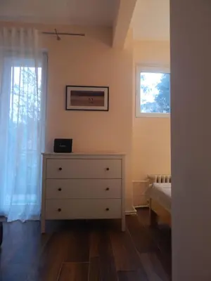 a bedroom with a dresser and a window at Apartman Luka in Vrnjačka Banja