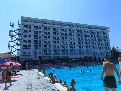 people in a swimming pool in front of a hotel at Apartman ELENA in Jagodina