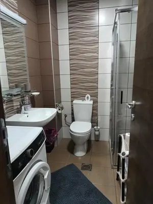 a bathroom with a toilet sink and a washing machine at Apartman ELENA in Jagodina