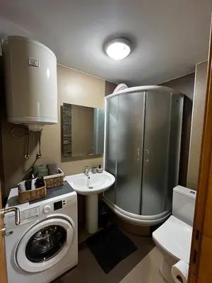 a bathroom with a washing machine and a sink at Apartman Riva Parking Garaža in Kraljevo