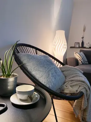 a hammock chair with a plate on a table in a living room at Apartman Riva Parking Garaža in Kraljevo